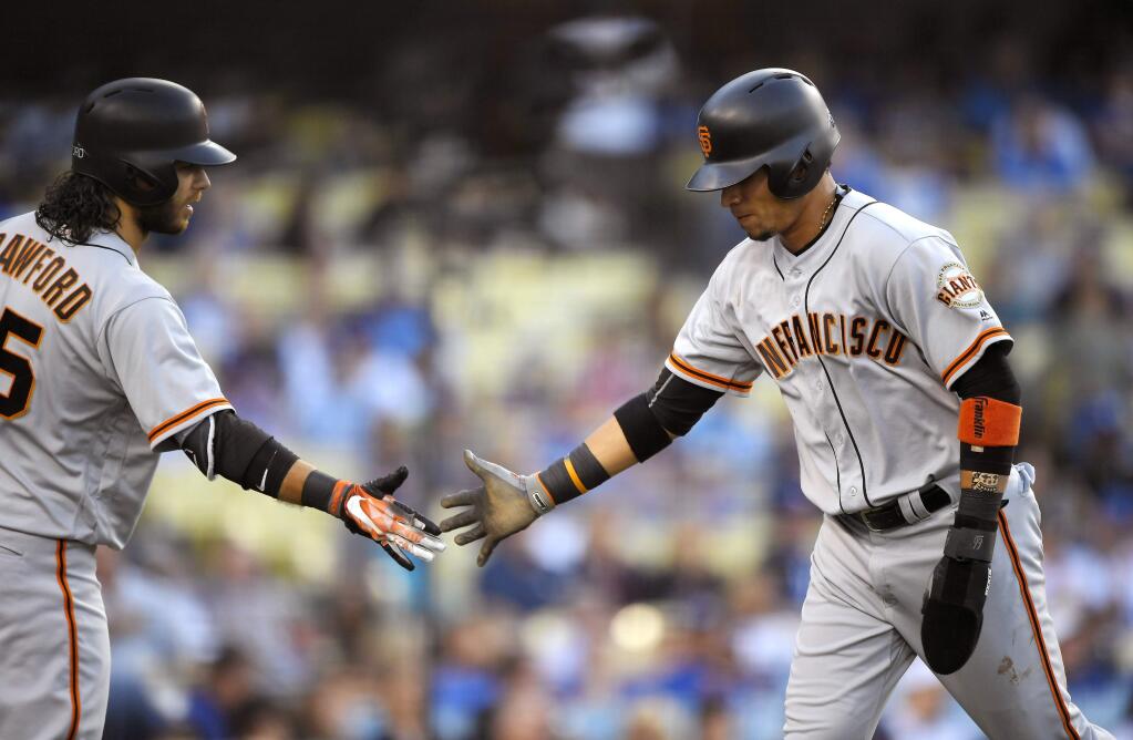 San Francisco Giants' Gorkys Hernandez, right, is congratulated by Brandon Crawford after scoring on a single by Buster Posey during the first inning of a baseball game against the Los Angeles Dodgers, Saturday, Sept. 23, 2017, in Los Angeles. (AP Photo/Mark J. Terrill)