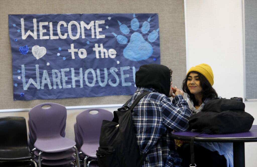 Roseland Collegiate Prep seniors Sissi Serrato, 17, right, and Brandon Esparza, 17, hang out during a break in classes during the first day at the old Roseland University Prep warehouse in Santa Rosa, on Monday, December 11, 2017. The Roseland Collegiate Prep campus was severely damaged during the Tubbs fire, and students had been attending class at two different elementary schools until moving to their new location on Monday. (BETH SCHLANKER/ The Press Democrat)