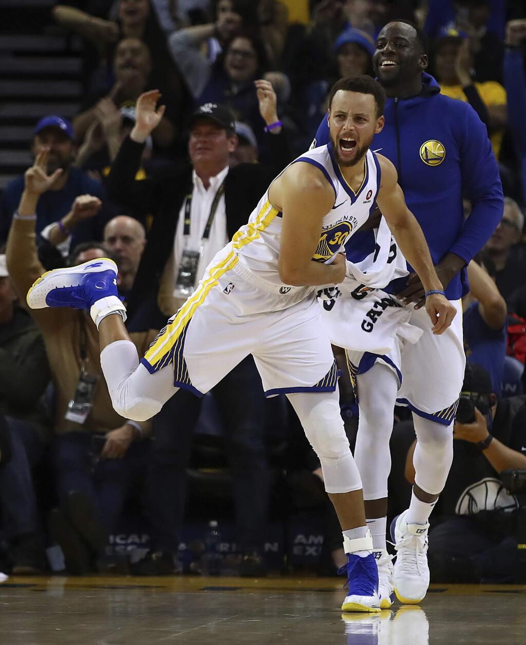 Golden State Warriors' Stephen Curry (30) and Draymond Green celebrate a score against the Denver Nuggets during the second half of an NBA basketball game Monday, Jan. 8, 2018, in Oakland, Calif. (AP Photo/Ben Margot)