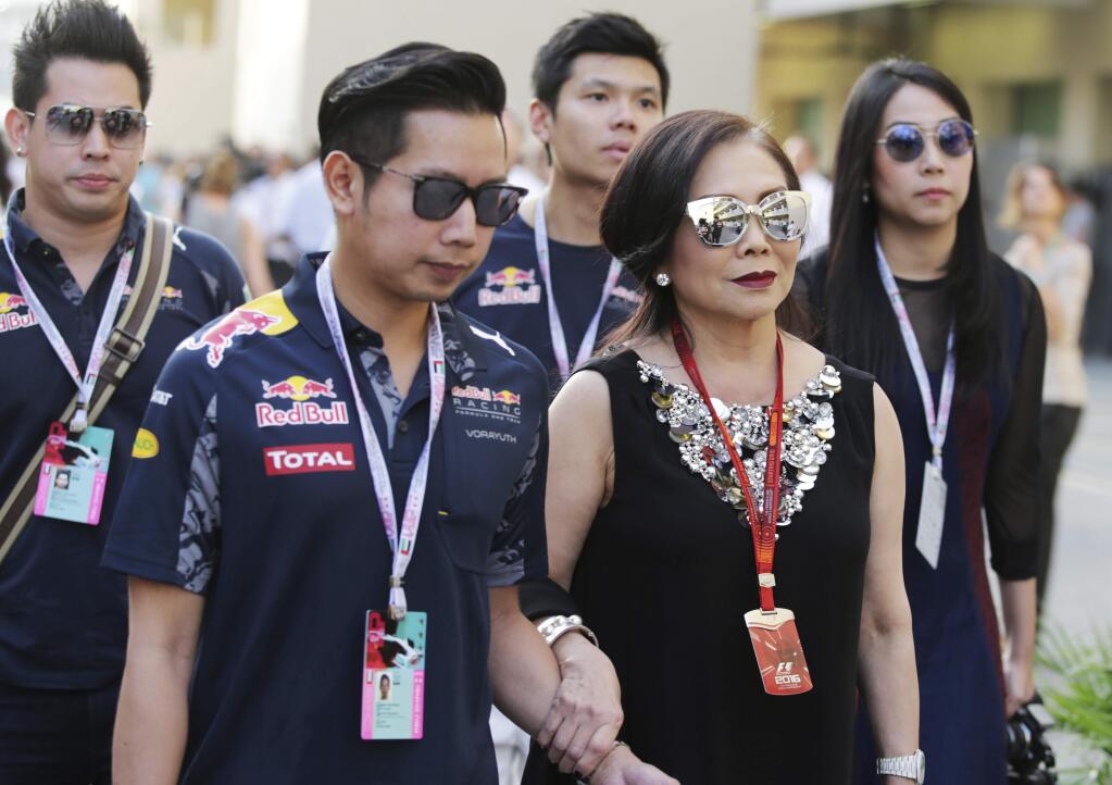 In this Nov. 26, 2016, photo provided by XPB Images, Vorayuth 'Boss' Yoovidhya, second left, whose grandfather co-founded energy drink company Red Bull, walks with his mother Daranee, second right, at the Formula 1 Grand Prix in Abu Dhabi. Vorayuth is accused of killing a Thai police officer in a hit-and-run in 2012, yet he still has not appeared to face charges. (XPB Images via AP)