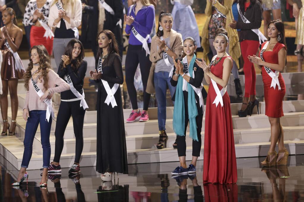 Miss Universe contestants clap as they rehearse, Saturday, Jan. 24, 2015, at Florida International University in Miami. The Miss Universe pageant will be held Jan. 25, in Miami. (AP Photo/Wilfredo Lee)