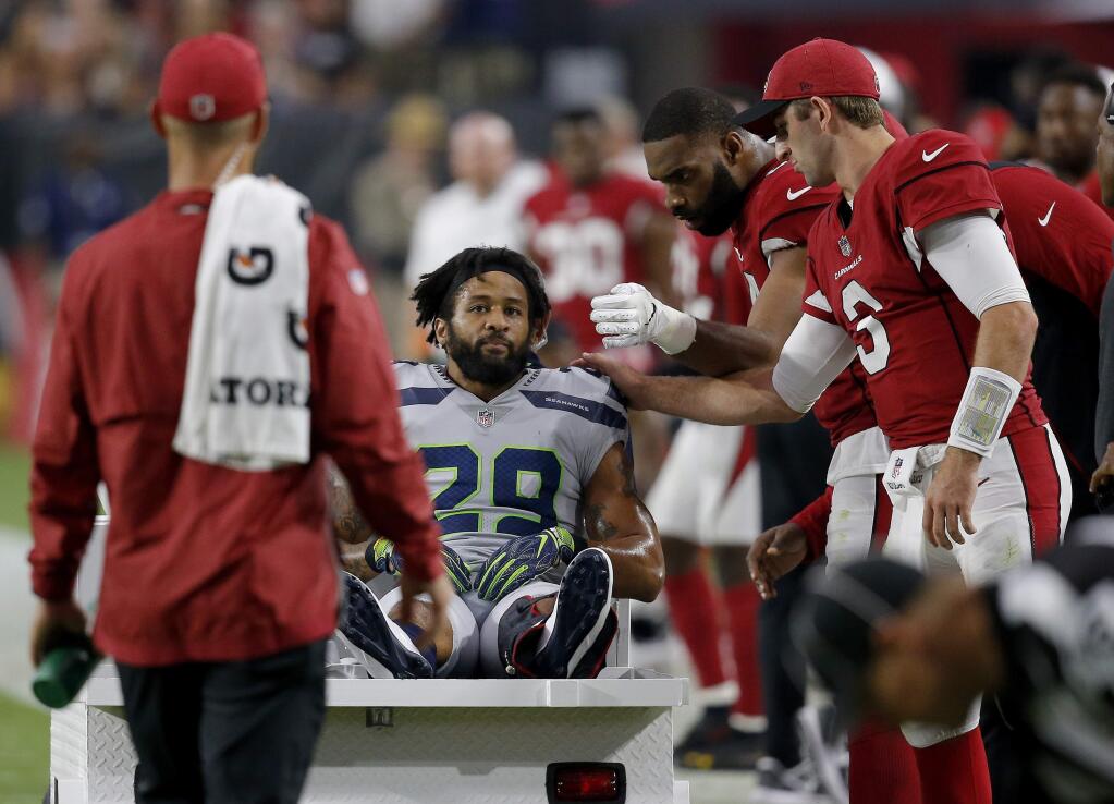 In this Sept. 30, 2018, file photo, Seattle Seahawks defensive back Earl Thomas (29) is greeted by Arizona Cardinals players as he leaves the field after breaking his leg during the second half in Glendale, Ariz. (AP Photo/Ross D. Franklin, File)