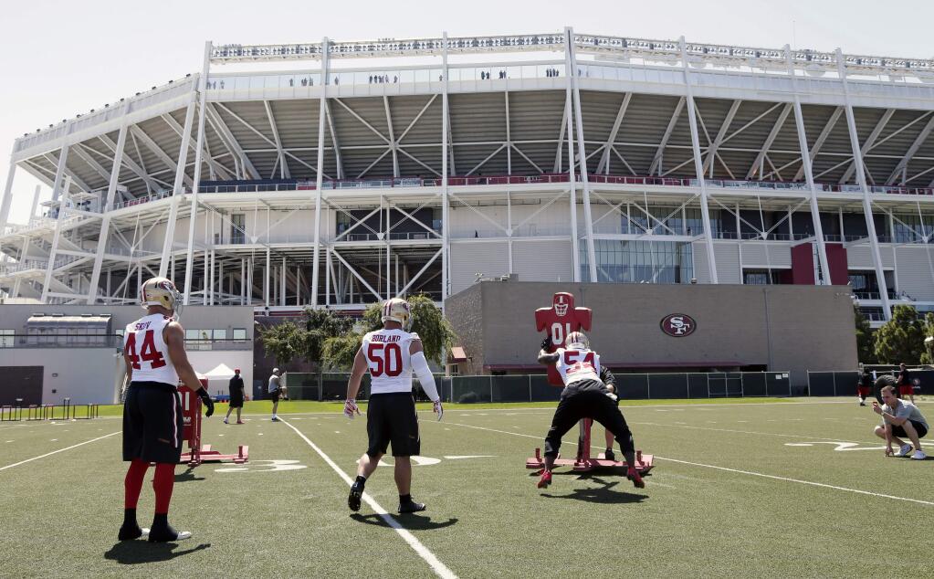 San Francisco 49ers linebackers workout in a facility adjacent to Levi's Stadium, background, during an NFL football training camp on Friday, July 25, 2014, in Santa Clara, Calif. (AP Photo)