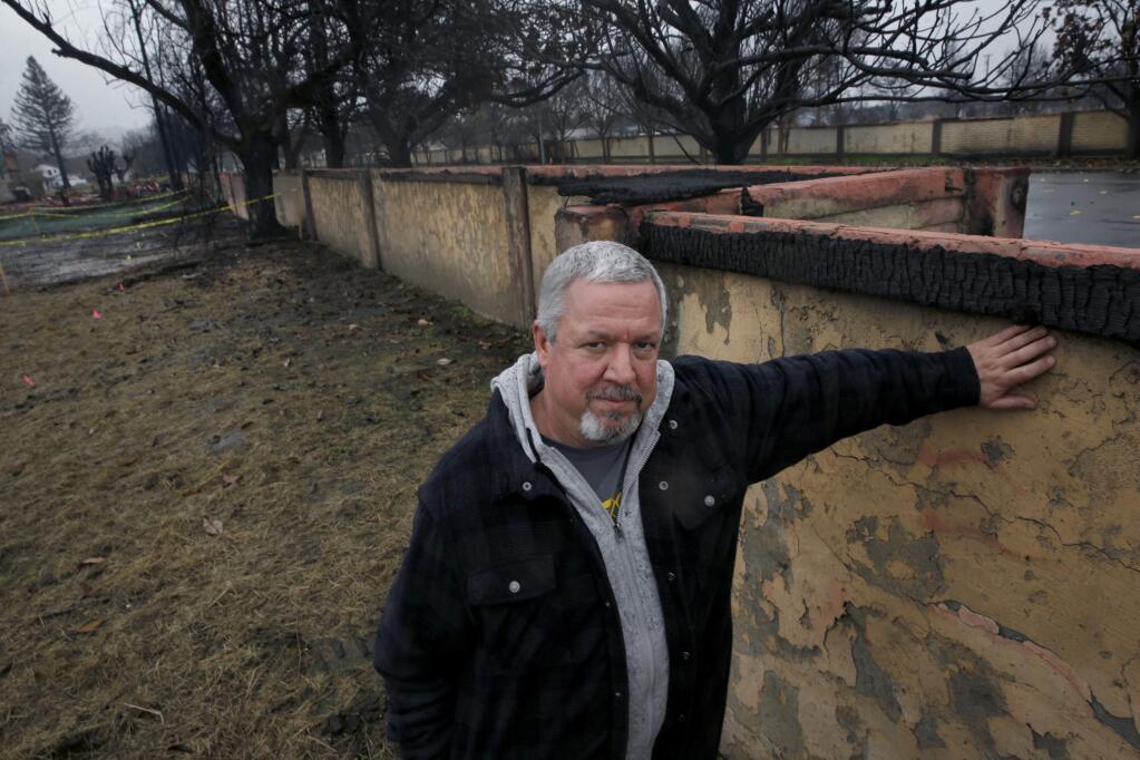 Coffey Park resident Kevin Johnson stands next to one of two 1,500-foot-long walls lining Hopper Avenue on Wednesday, Jan. 24, 2018 in Santa Rosa, California. (BETH SCHLANKER/ PD)