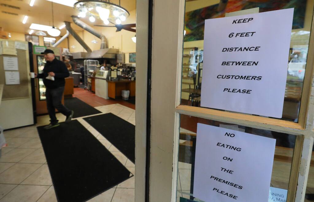 A sign at the Downtown Bakery & Creamery instructs customers to keep a distance between them when visiting the store, in Healdsburg on Wednesday, March 18, 2020. (Christopher Chung/ The Press Democrat)