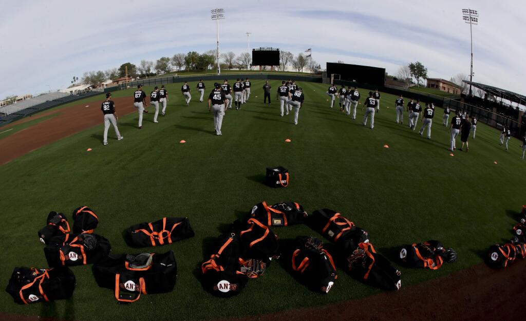 Members of the San Francisco Giants warms up during practice in Scottsdale, Ariz., Tuesday, Feb. 14, 2017. (AP Photo/Chris Carlson)