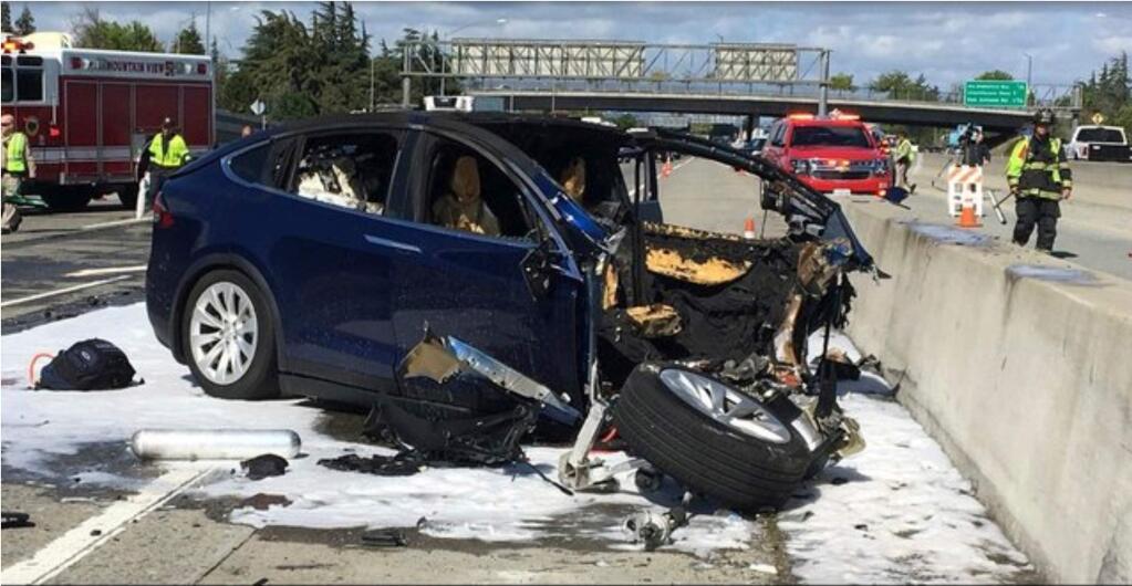 FILE- In this Friday, March 23, 2018, file photo provided by KTVU, emergency personnel work a the scene where a Tesla electric SUV crashed into a barrier on U.S. Highway 101 in Mountain View, Calif. (KTVU via AP, File)