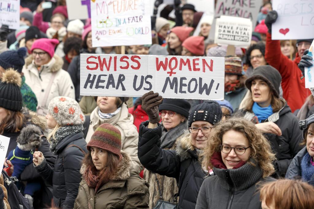 Protesters hold placards with slogans, during the Women's March rally, in Geneva, Switzerland, Saturday, Jan. 21, 2017. People gathered against the inauguration of US President Donald Trump. (Salvatore Di Nolfi/Keystone via AP)