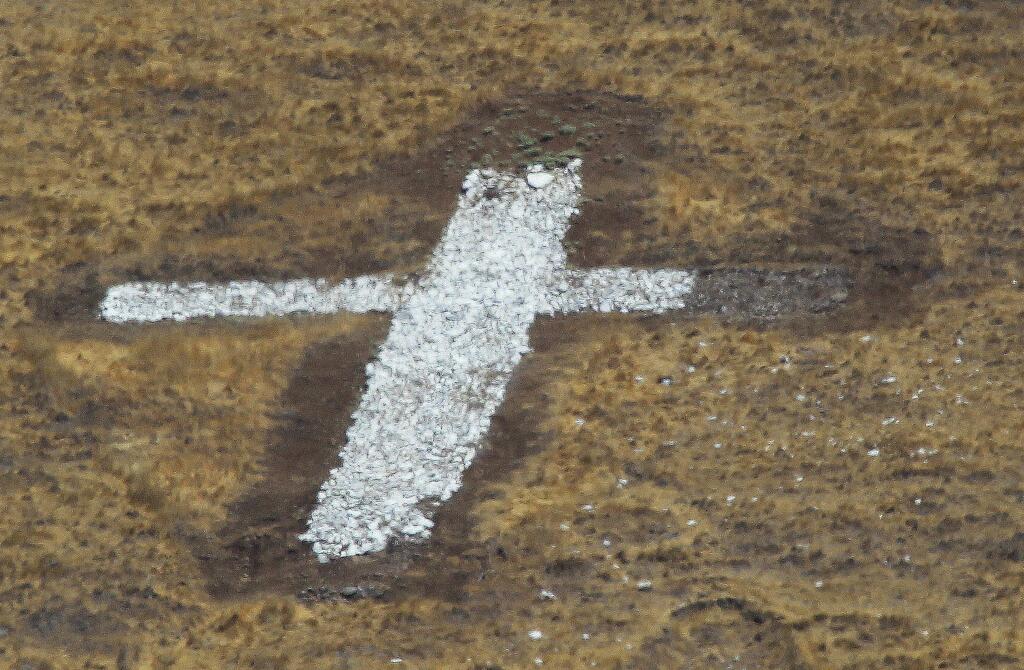 Part of a large cross made of white painted rocks was recently removed from the steep slope above the St. Francis Acres/Skyhawk neighborhoods. (The Press Democrat)