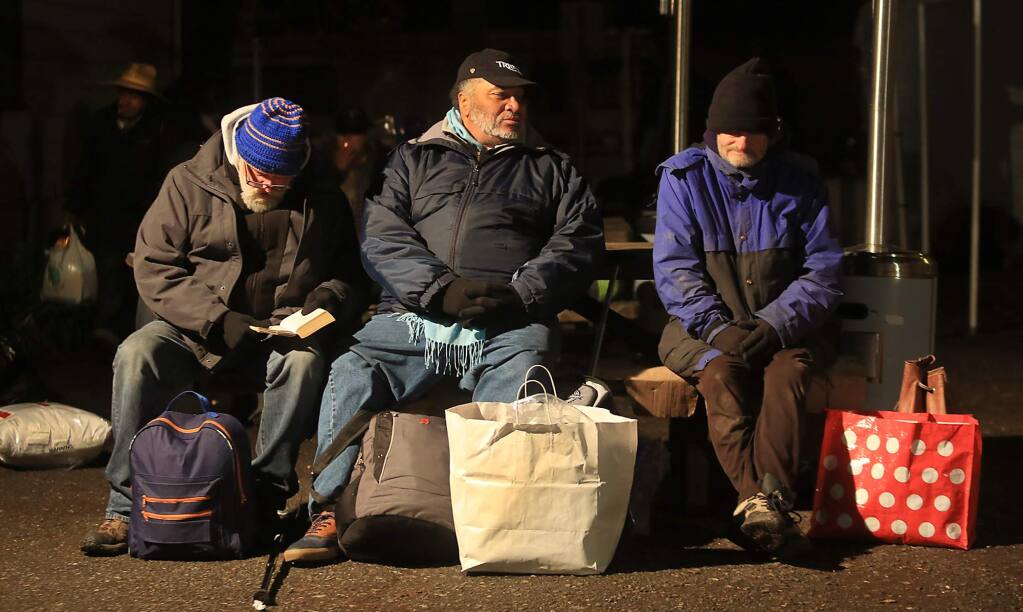 From left, Pete Magoni, Fleming Smith and Robert White, bundled up against the cold, wait for a ride to the Sam Jones Hall shelter, Friday Dec. 25, 2015 at Catholic Charities on Morgan Street in Santa Rosa. (Kent Porter / Press Democrat)