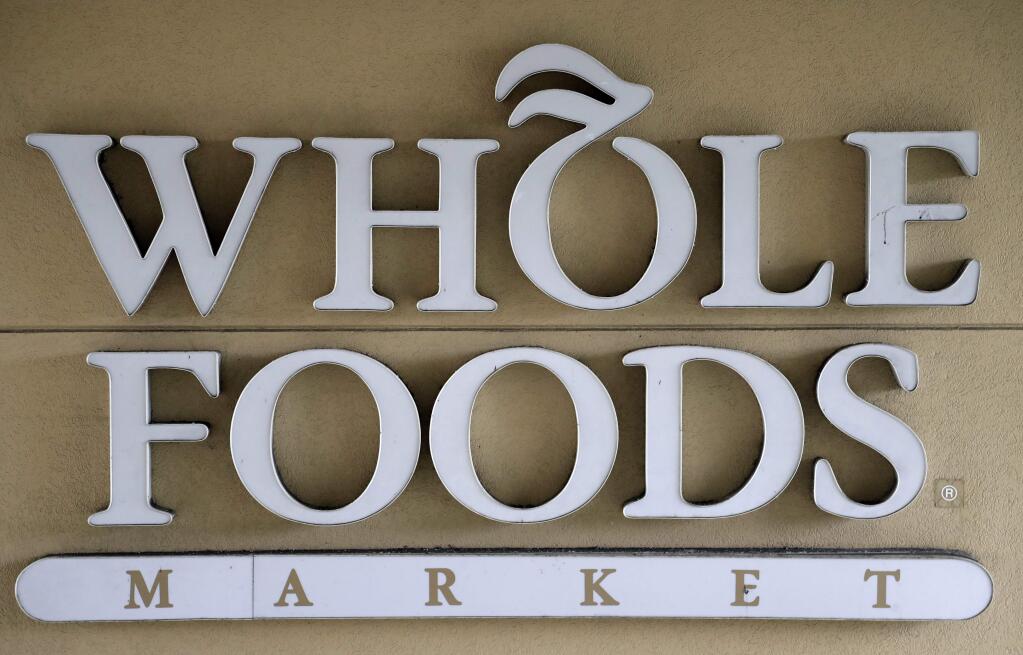 FILE - In this Aug. 28, 2017 file photo, a sign at a Whole Foods Market greets shoppers in Tampa, Fla. The online retailing giant plans to roll out two-hour delivery at the organic grocer this year to those who pay for Amazon's $99-a-year Prime membership. The move is the latest by Amazon to put its stamp on its recent purchase of Whole Foods. (AP Photo/Chris O'Meara, File)