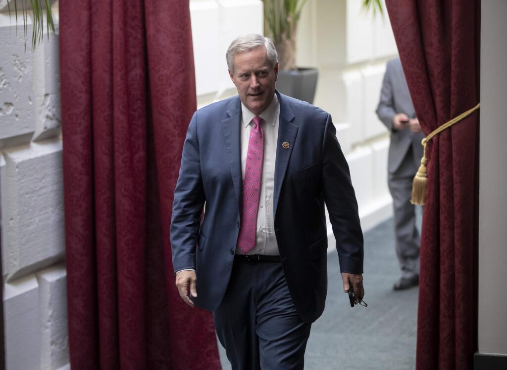 Rep. Mark Meadows, R-N.C., left, chairman of the conservative House Freedom Caucus, heads to a floor vote after President Donald Trump met with House Republicans to discuss a GOP immigration bill amid the public outcry over the administration's approach to illegal border crossings and separation of children from immigrant parents, on Capitol Hill in Washington, Tuesday, June 19, 2018. (AP Photo/J. Scott Applewhite)