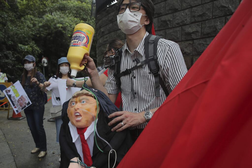 Pro-China supporters hold the effigy of U.S. President Donald Trump outside the U.S. Consulate during a protest, in Hong Kong, Saturday, May 30, 2020. President Donald Trump has announced a series of measures aimed at China as a rift between the two countries grows. He said Friday that he would withdraw funding from the World Health Organization, end Hong Kong's special trade status and suspend visas of Chinese graduate students suspected of conducting research on behalf of their government. (AP Photo/Kin Cheung)