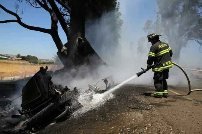Fire crews work to extinguish a fiery truck crash on Lakeville Highway near Petaluma on Wednesday, June 29, 2016. (CHRISTOPHER CHUNG/ PD)