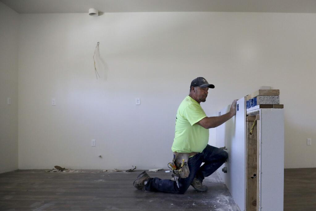 Tom Riggs of Riggs Drywall works on the interior of a unit at the Healdsburg Family Apartments under construction in Healdsburg on Tuesday, July 17, 2018. (Beth Schlanker/ The Press Democrat)