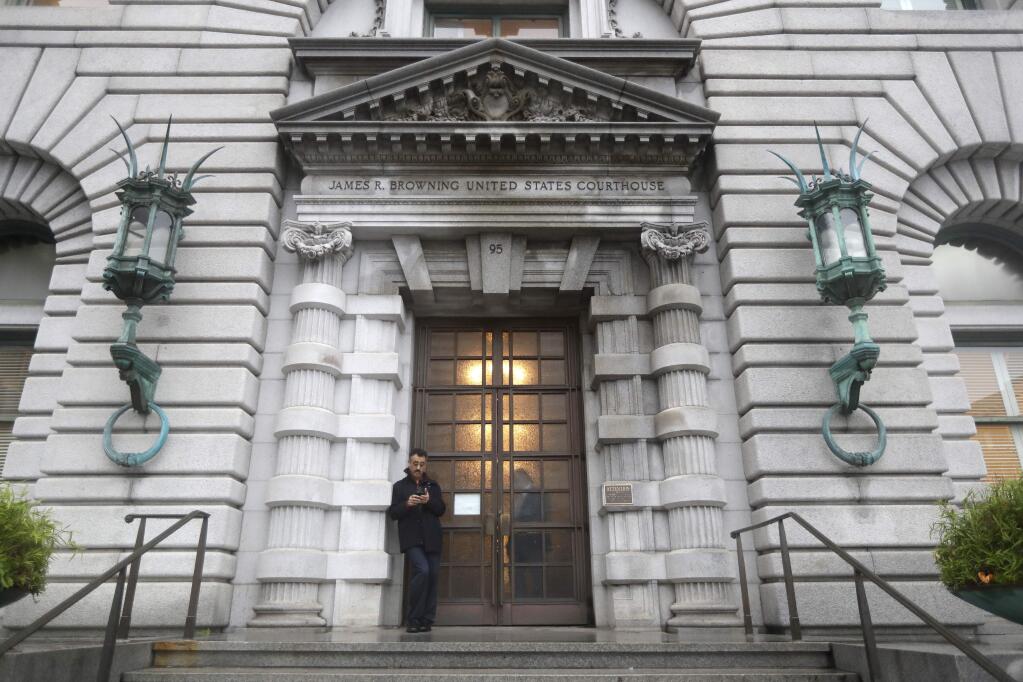 FILE - In this Feb.9, 2017 file photo, a man stands outside the main door outside the 9th U.S. Circuit Court of Appeals building in San Francisco. The state of Texas on Wednesday, Feb. 15, 2017, defended President Donald Trump's ban on travelers from seven predominantly Muslim nations as an assertion of presidential authority intended to protect the country from terrorists, splitting with states that have denounced the order as a religious attack. (AP Photo/Marcio Jose Sanchez, file)