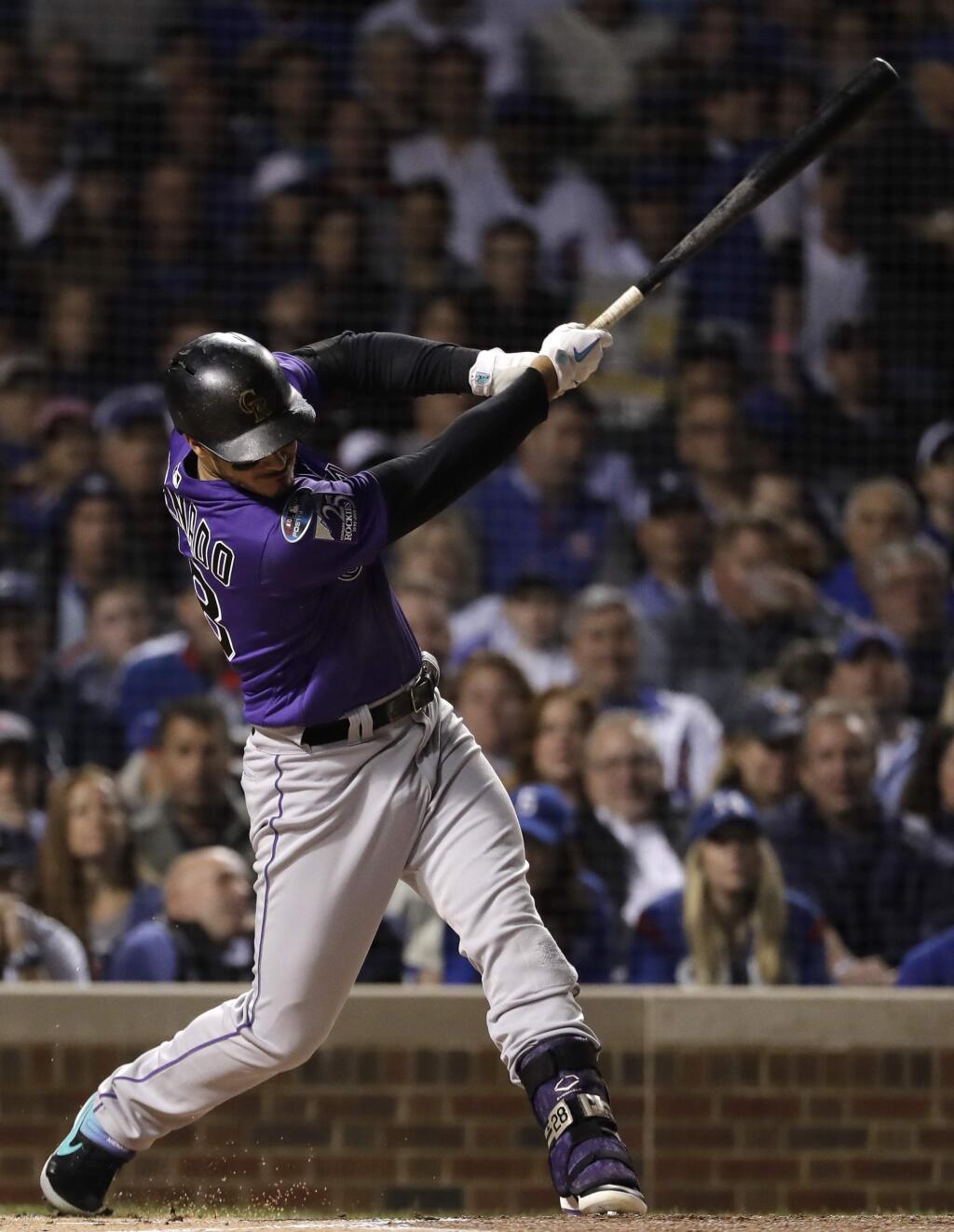 The Colorado Rockies' Nolan Arenado hits a sacrifice fly against the Chicago Cubs during the first inning of the National League wild-card game Tuesday, Oct. 2, 2018, in Chicago. (AP Photo/Nam Y. Huh)