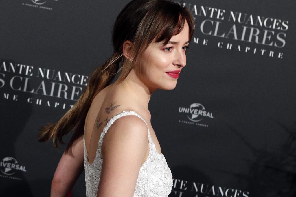 Dakota Johnson poses during a photocall for the world premiere of 'Fifty Shades Freed - 50 Nuances Plus Claires' at Salle Pleyel in Paris, Tuesday, Feb. 6, 2018. (AP Photo/Francois Mori)