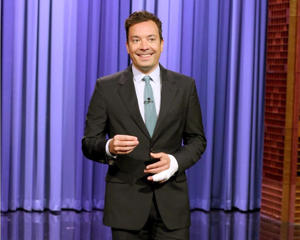In this image released by NBC, host Jimmy Fallon appears during his monologue on 'The Tonight Show Starring Jimmy Fallon,' Monday, July 13, 2015 in New York. Fallon was back at work Monday following a June 26 accident that injured his finger in his New York home. (Douglas Gorenstein/NBC via AP)