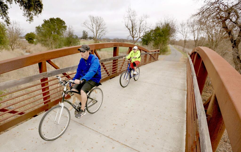 Bicyclists ride on the Santa Rosa Creek Trail near Willowside Road on Wednesday. The county's updated bike plan envisions a 1,060-mile path system, but limited funding means the 977 proposed segments won't be finished anytime soon, officials say.(Kent Porter / Press Democrat)