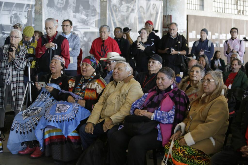 Sacheen Littlefeather, second from right in the front row, listens to ceremonies marking the 50th anniversary of the Native American occupation of Alcatraz Island Wednesday, Nov. 20, 2019, in San Francisco. About 150 people gathered at Alcatraz to mark the 50th anniversary of a takeover of the island by Native American activists. Original occupiers, friends, family and others assembled Wednesday morning for a program that included prayer, songs and speakers. They then headed to the dock to begin restoring messages painted by occupiers on a former barracks building. In 1973 Littlefeather represented Marlon Brando at the Oscars to decline his Best Actor award. (AP Photo/Eric Risberg)