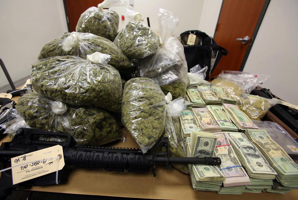 Guns, cash and marijuana seized by authorities in 2013 from a home north of Santa Rosa. (JOHN BURGESS/ PD FILE)