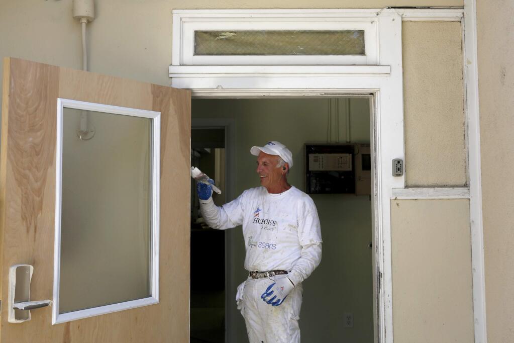 Volunteer Jerry Thompson paints a new front door for the reopening of the COTS Family Center on Monday, June 15, 2015 in Petaluma. (BETH SCHLANKER / The Press Democrat)