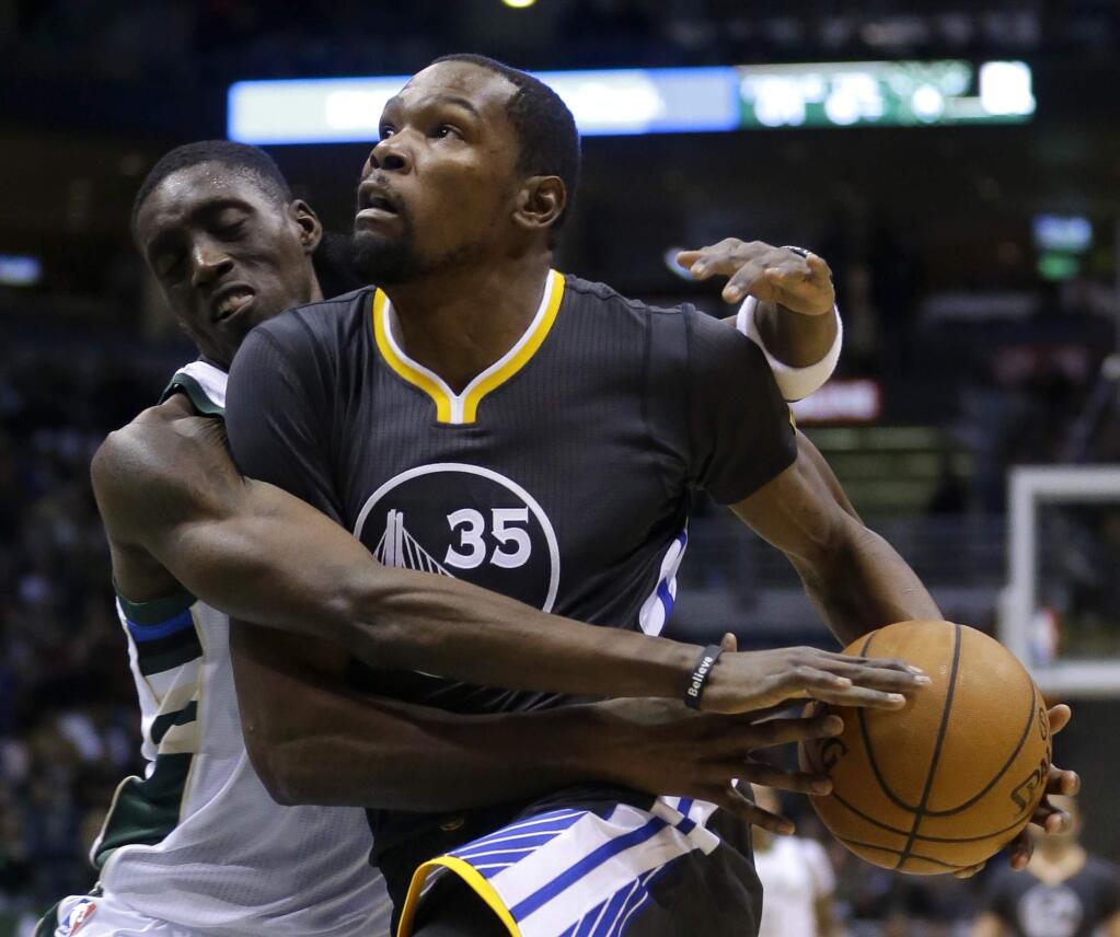 Golden State Warriors' Kevin Durant (35) is fouled by Milwaukee Bucks' Tony Snell during the first half of an NBA basketball game Saturday, Nov. 19, 2016, in Milwaukee. (AP Photo/Aaron Gash)