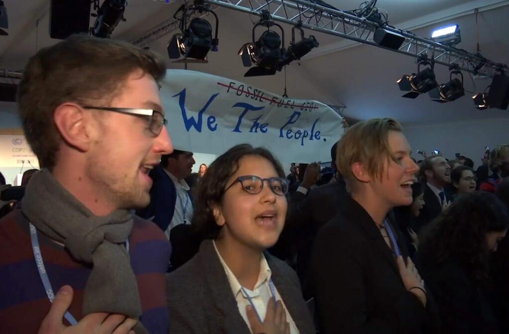 In this image made from video, protesters sing during climate talks at the World Climate Conference in Bonn, Germany, Monday, Nov. 13, 2017. About 200 protesters have disrupted a U.S. government-hosted event on coal and nuclear energy at the U.N. climate talks in Germany. The mostly young protesters stood up 10 minutes into the event in Bonn and began singing an anti-coal song to demonstrate against the use of fossil fuels. The event late Monday was the only one organized by the U.S. delegation at the talks. (AP Photo)