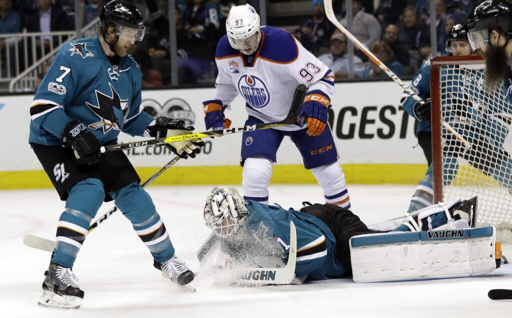 San Jose Sharks goalie Martin Jones, bottom, makes a stop next to teammate Paul Martin (7) and Edmonton Oilers' Ryan Nugent-Hopkins (93) during the second period in Game 4 of a first-round NHL hockey playoff series Tuesday, April 18, 2017, in San Jose, Calif. (AP Photo/Marcio Jose Sanchez)