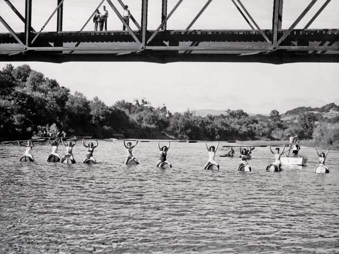 At The Races: Entrants in a 200-yard wine-barrel race on the Russian River raise their paddles as a few admirers look on from Healdsburg Veterans Memorial Bridge. The race was part of the 1947 Healdsburg Harvest Festival, attended by thousands. (Sonoma County Wine Library)