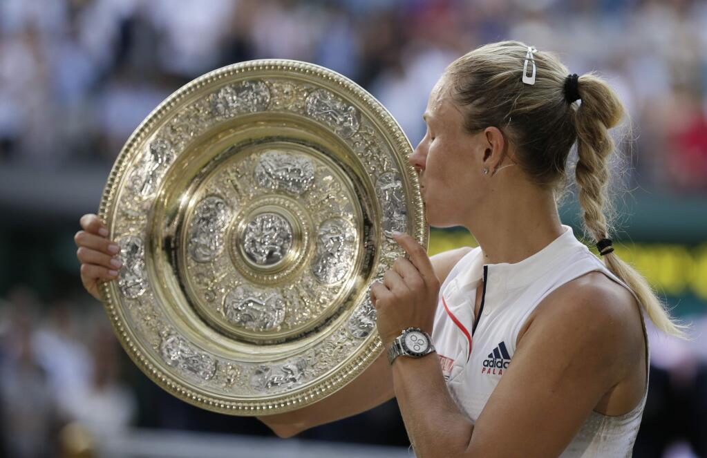 Germany's Angelique Kerber kisses the trophy after winning the women's singles final match against Serena Williams of the United States, at the Wimbledon Tennis Championships, in London, Saturday July 14, 2018.(AP Photo/Tim Ireland)