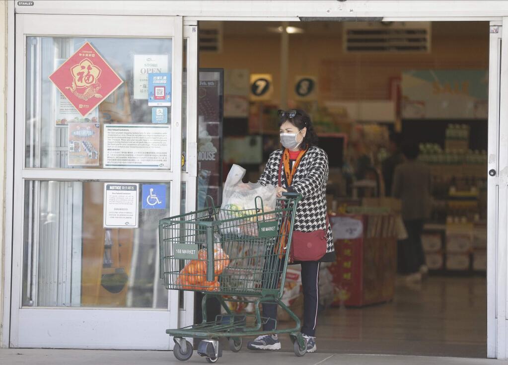 Customers wear protective masks as they shop at the 168 Market in Alhambra, Calif., Friday, Jan. 31, 2020. As China grapples with the growing coronavirus outbreak, Chinese people in the Los Angeles area, home to the third-largest Chinese immigrant population in the United States, are encountering a cultural disconnect as they brace for a possible spread of the virus in their adopted homeland. (AP Photo/Damian Dovarganes)