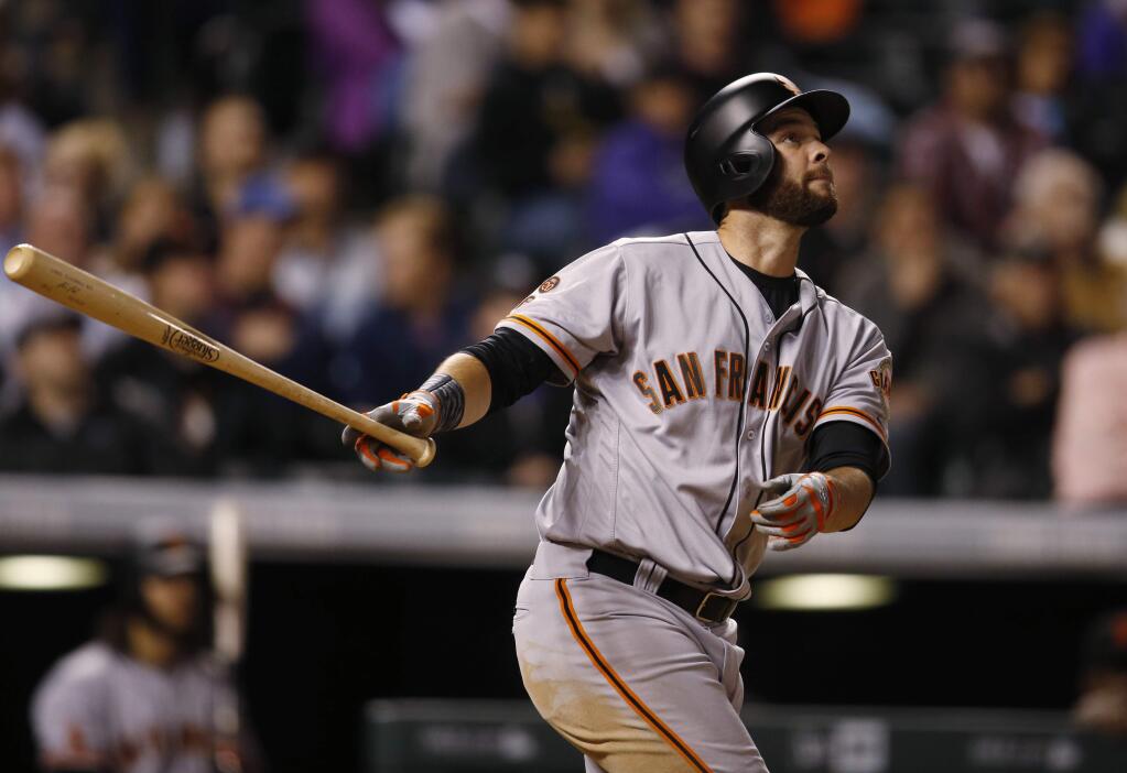 San Francisco Giants' Brandon Belt follows the flight of his solo home run off Colorado Rockies relief pitcher Miguel Castro during the eighth inning of a baseball game Wednesday, April 13, 2016, in Denver. Colorado won 10-6. (AP Photo/David Zalubowski)