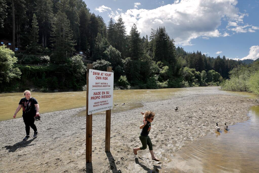 Guerneville resident Sonya, who declined to provide her last name, lets her son Teddy, 5, play in calm water while they walk along Monte Rio Beach in Monte Rio, California, on Thursday, May 23, 2019. (Alvin Jornada / The Press Democrat)
