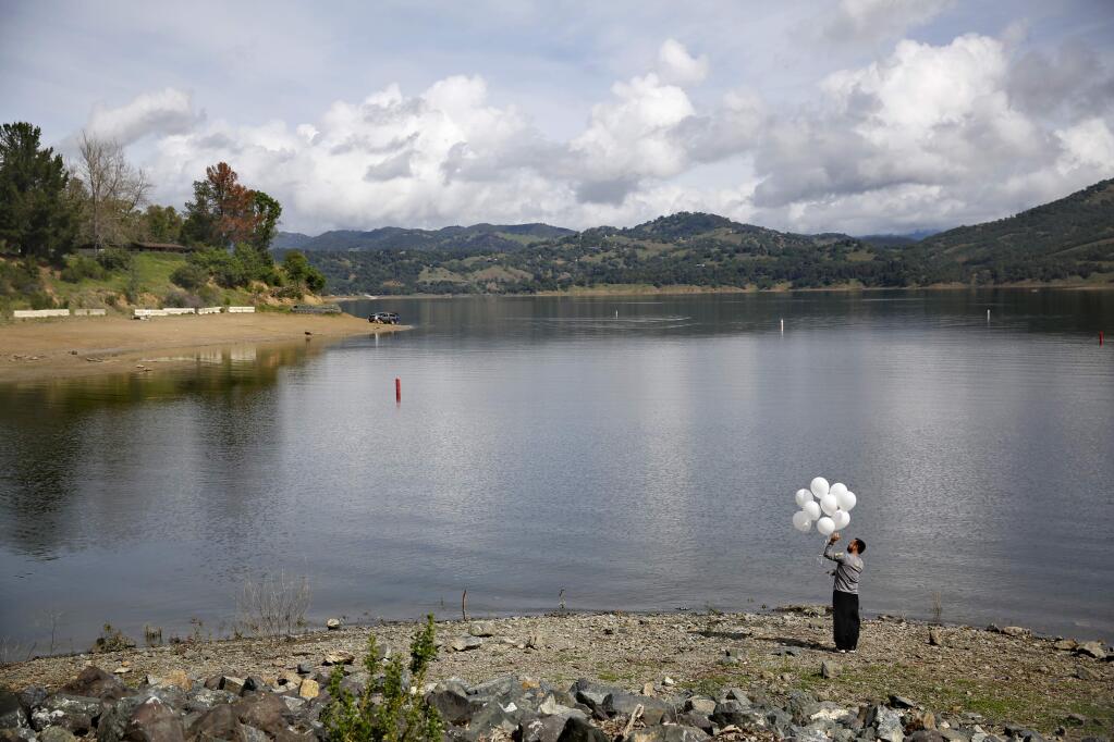 Angel Torres takes a moment to remember his late niece Yuri Ortiz, 2, before releasing balloons on what would be her 9th birthday at Lake Mendocino on Sunday, March 22, 2015 in Ukiah, California . (BETH SCHLANKER/ The Press Democrat)