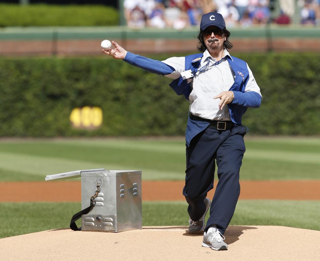 FILE - In this Sept. 17, 2016 file photo, Stephen Colbert, playing the role of Wrigley Field hot dog vendor Donny Franks, throws out a ceremonial first pitch before a baseball game between the Milwaukee Brewers and the Chicago Cubs, in Chicago. The Chicago Cubs are trying to do something that hasn't happened in the lifetime of anyone born in the last 108 years: Win a World Series. (AP Photo/Nam Y. Huh, File)