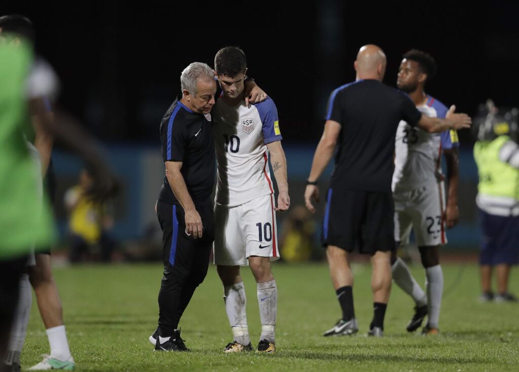 In this Oct. 10, 2017, file photo, the United States' Christian Pulisic, No. 10, is comforted after losing 2-1 against Trinidad and Tobago during a World Cup qualifying match in Couva, Trinidad. (AP Photo/Rebecca Blackwell, File)