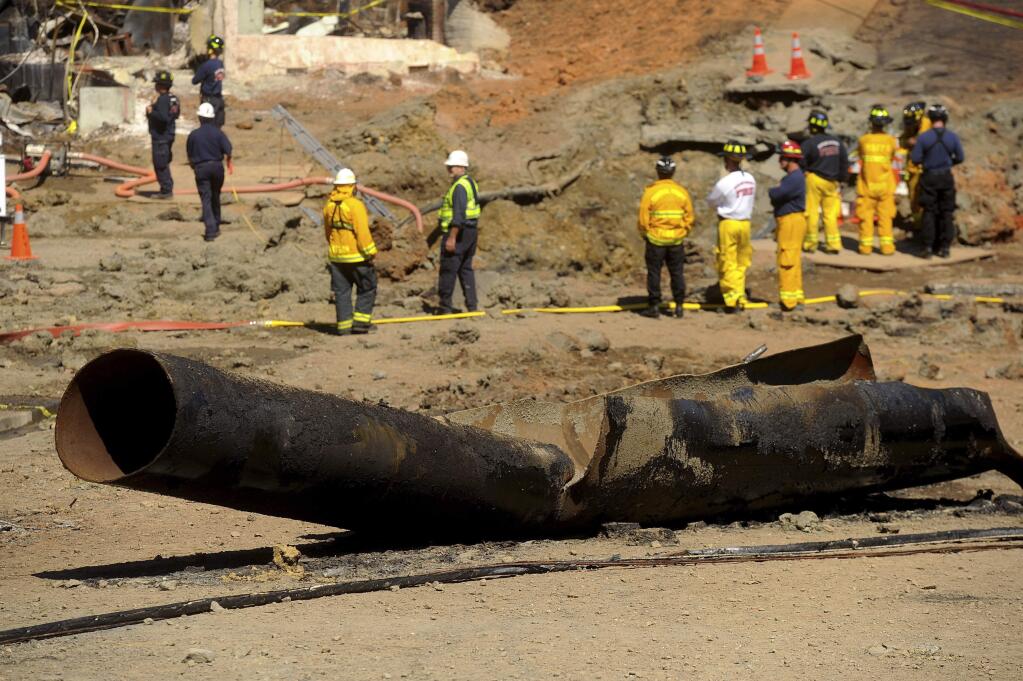 FILE - In this Sept. 11, 2010, file photo, a Pacific Gas & Electric natural gas line lies broken on a San Bruno, Calif., road after a massive explosion. U.S. prosecutors are urging a federal judge to work with a court-appointed monitor to determine ways Pacific Gas & Electric Co. can prevent its equipment from starting more wildfires. In a court filing Wednesday, Jan. 23, 2019, the U.S. attorney's office in San Francisco said Judge William Alsup should refrain from immediately imposing new requirements on the utility. (AP Photo/Noah Berger, File)