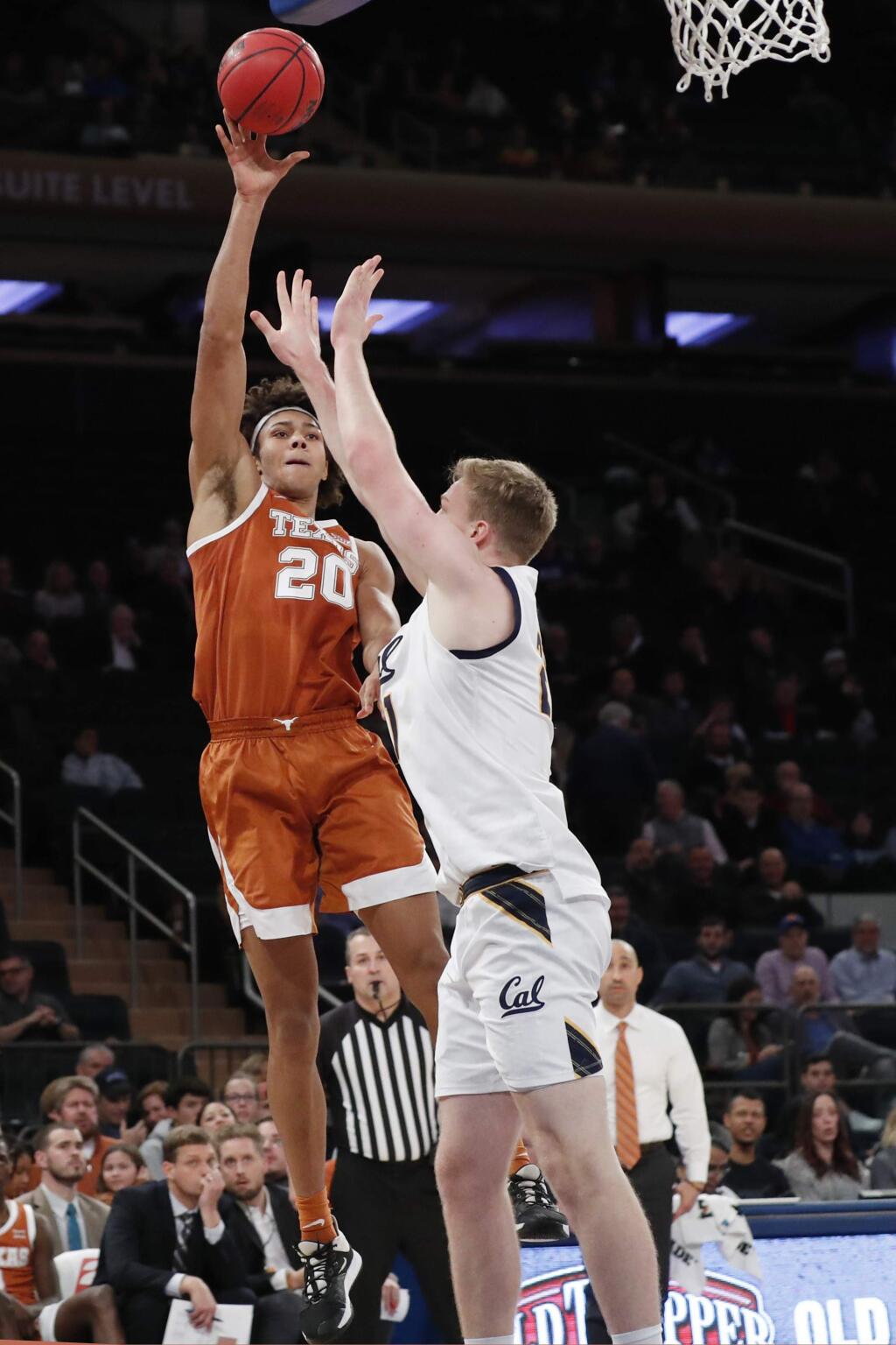 Texas forward Jericho Sims (20) passes around Cal forward Lars Thiemann (21) during the second half in the 2K Empire Classic, Thursday, Nov. 21, 2019, in New York. (AP Photo/Kathy Willens)