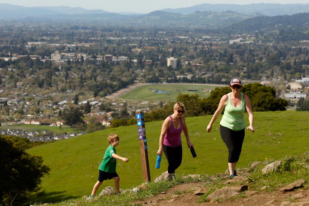 Amazing views can be seen around every corner at Taylor Mountain in Santa Rosa. It became a regional park in 2013. Michaela Kalemba (right), Molly Nunn and her son Dylan hike toward the top in 2016. (Alvin Jornada / The Press Democrat file)