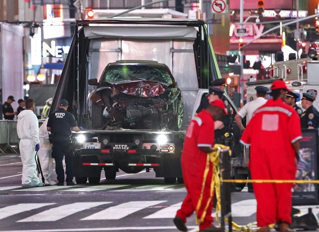 The car driven by a man who steered his car onto a busy Times Square sidewalk, killing a teenager and injuring nearly two dozen others, is removed by police and investigators from the crime scene area, Thursday, May 18, 2017, in New York. The driver, a 26-year-old U.S. Navy veteran, told officers he was hearing voices and expected to die, two law enforcement officials said. (AP Photo/Kathy Willens)