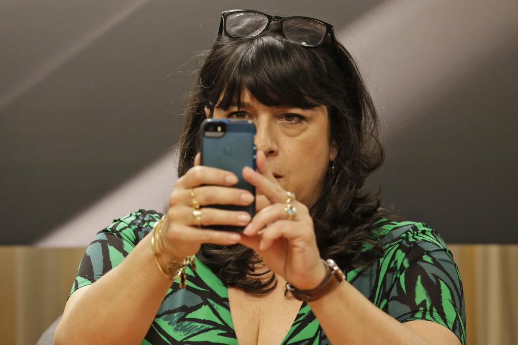 Author EL James takes a picture of photographers before signing her new book, 'Grey,' at a Barnes and Noble bookstore in New York, Thursday, June 18, 2015. #AskELJames trended nationwide as the 'Fifty Shades of Grey' writer took questions online. (AP Photo/Mary Altaffer)