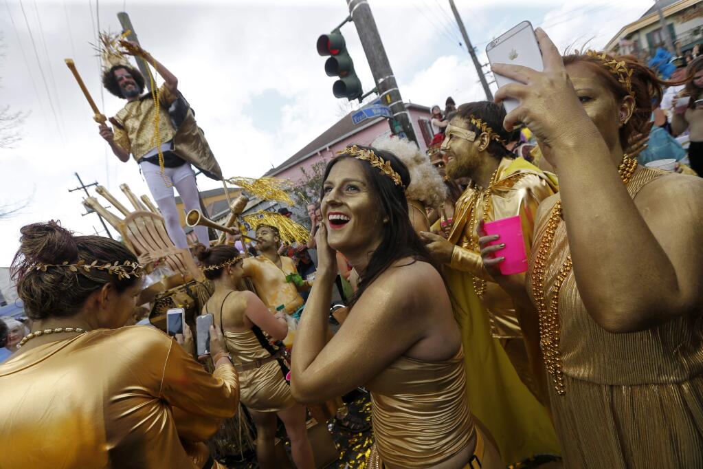 FILE - In this Feb. 28, 2017, file photo, revelers congregate at the start of the Society of Saint Anne Mardi Gras parade in New Orleans. The city celebrates its tricentennial in 2018. (AP Photo/Gerald Herbert, File)