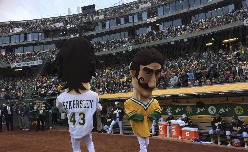 Oakland Athletics mascots resembling Dennis Eckersley, left, and Rollie Fingers entertain fans prior to the team's game against the Chicago White Sox on Tuesday, April 17, 2018, in Oakland. The A's hosted a 'Free Baseball' night at the stadium, to celebrate the A's first game in Oakland, which was held exactly 50 years ago against the Baltimore Orioles. (AP Photo/Ben Margot)