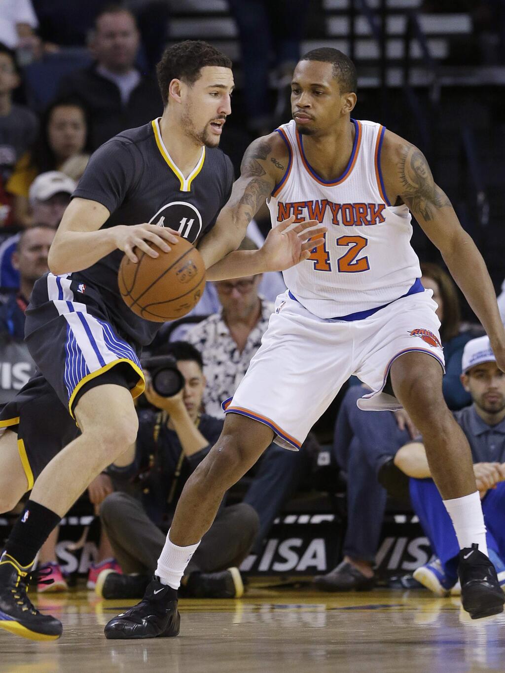 Golden State Warriors guard Klay Thompson (11) drives against New York Knicks forward Lance Thomas (42) during the first half of a game in Oakland, Saturday, March 14, 2015. (AP Photo/Jeff Chiu)