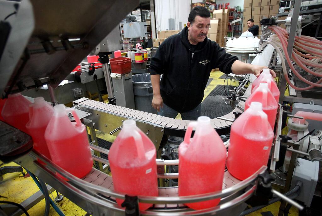 Eduardo Vega keeps bottles of General Hydroponics FloraBloom moving along the bottling line at the company's production facility in Sebastopol in 2012. (CHRISTOPHER CHUNG/ PD FILE)