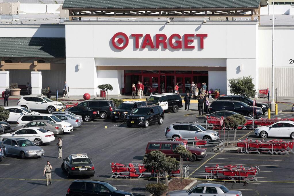 Police taped off a section of the parking lot of a Target store after a fatal shooting Monday, Sept. 21, 2015, in Sand City, Calif. Monterey District Attorney Dean Flippo tells the Santa Cruz Sentinel officers were trying to serve a warrant to men sitting in a car at the store when the gun fight broke out. (Vern Fisher/The Monterey County Herald via AP)