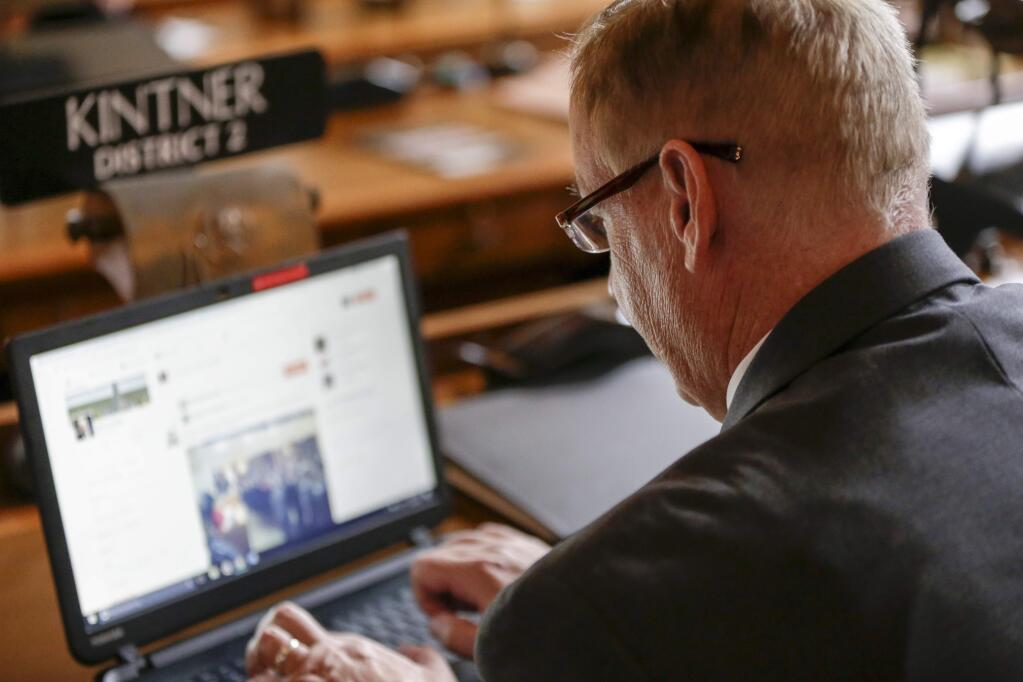In this Jan. 4, 2017 photo, Neb. state Sen. Bill Kintner of Papillion works on his laptop in the legislative Chamber on the first day of the 2017 legislative session, in Lincoln, Neb. Sen. Kintner could face expulsion from the Legislature for retweeting a talk show host's joke implying that Women's March demonstrators are too unattractive to sexually assault. Kintner's fellow lawmakers railed against him Tuesday in response to public outrage over his online posting, the latest in a long history of inflammatory statements. (AP Photo/Nati Harnik)