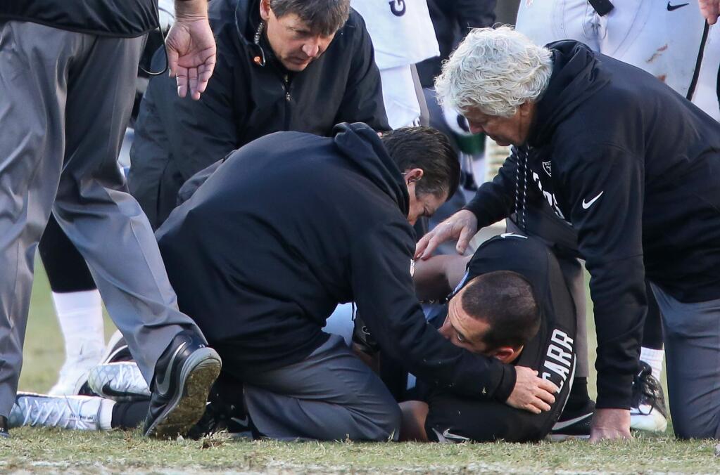 Oakland Raiders quarterback Derek Carr is helped on the field after being injured on a play in the fourth quarter against the Indianapolis Colts during their game in Oakland on Saturday, December 24. The Raiders defeated the Colts 33-25. (Christopher Chung / The Press Democrat)